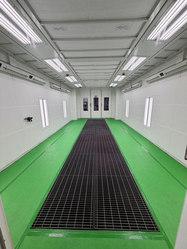 A clean booth with fresh green floor and clear black grates
